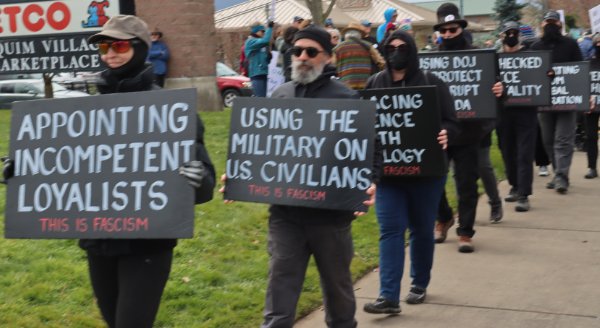 protesters in black holding anti-facist signs