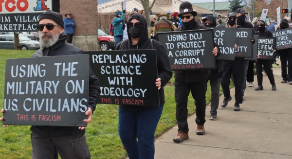protesters in black holding anti-facist signs