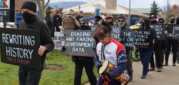 protesters in black holding anti-facist signs